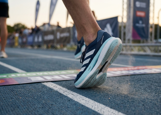 Adidas performance running shoes at a marathon finish line.