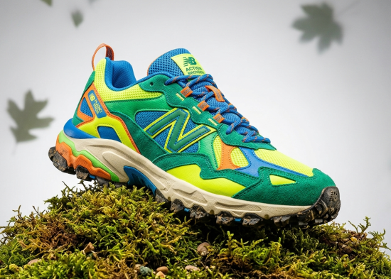 Studio shot of the New Balance Action Bronson Planet Frog runner on a mossy green surface.