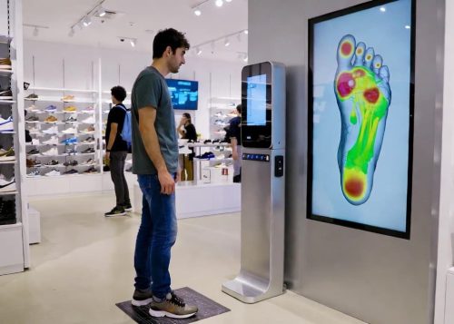 Customer receiving a 3D foot biomechanics scan inside a minimalist retail boutique.
